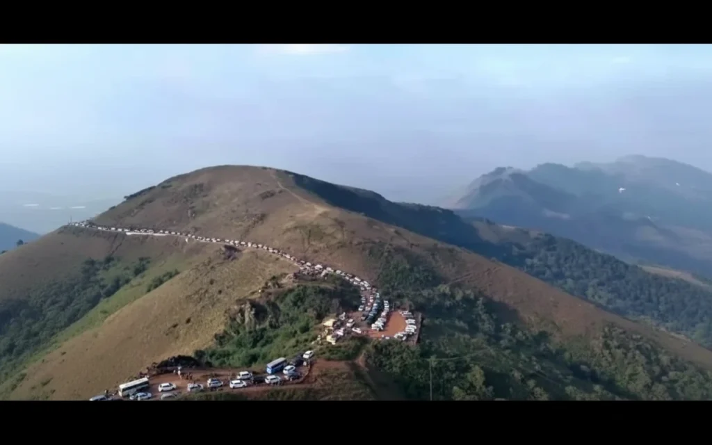 A peaceful Chikkamagaluru homestay surrounded by lush hills, with tourists arriving through eco-friendly travel options after vehicle restrictions.